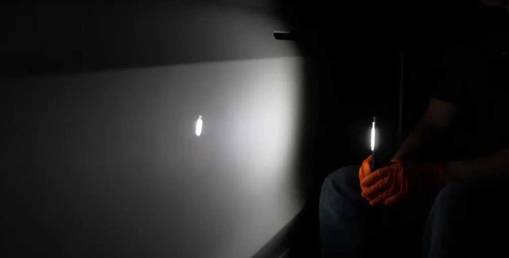 inspecting a vehicles paint work with a flashlight
